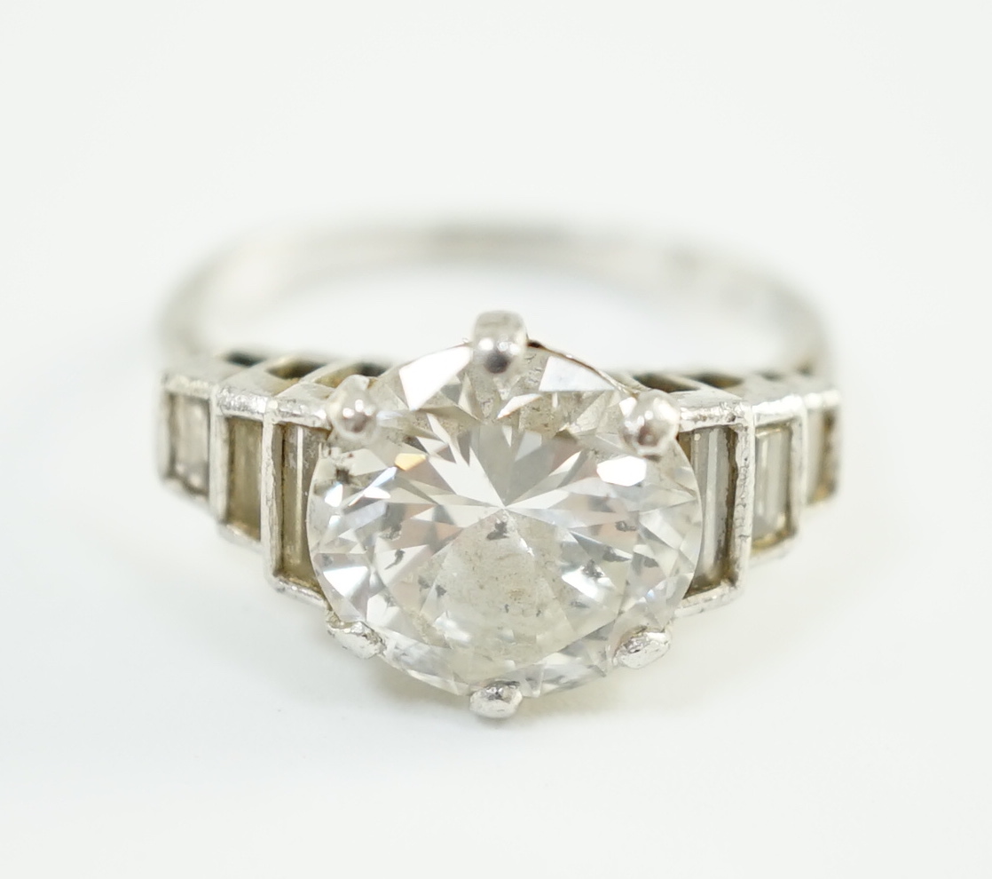 An Art Deco platinum and single stone diamond set ring, with six stone graduated baguette cut diamond set shoulders